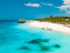 Rajska plaża na Zanzibarze, turkusowa woda, palmy i hotel na wodzie. Czy jest bezpiecznie? Tak, to idealne miejsce na wakacje.