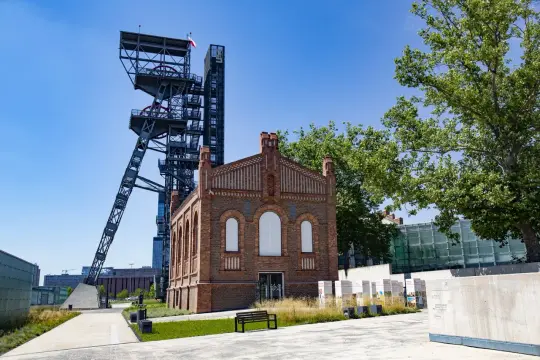 Dawna kopalnia w centrum miasta, idealne miejsce, by zobaczyć, co zwiedzić na Śląsku. Wieża szybu i ceglany budynek tworzą industrialny krajobraz.