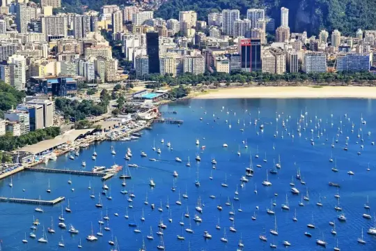 Widok na zatokę pełną łodzi i jachtów, z miastem w tle. Czy w Brazylii jest bezpiecznie? Turyści cieszą się pięknem Rio de Janeiro.