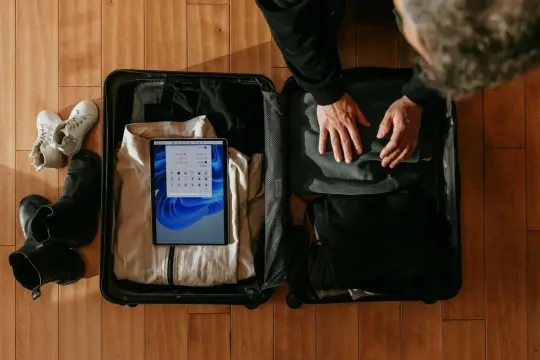 Pakowanie walizki: buty, ubrania i tablet. Zastanawiasz się, czy można przewozić pamiątki w bagażu podręcznym?
