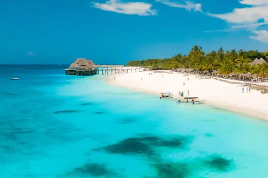 Rajska plaża na Zanzibarze, turkusowa woda, palmy i hotel na wodzie. Czy jest bezpiecznie? Tak, to idealne miejsce na wakacje.