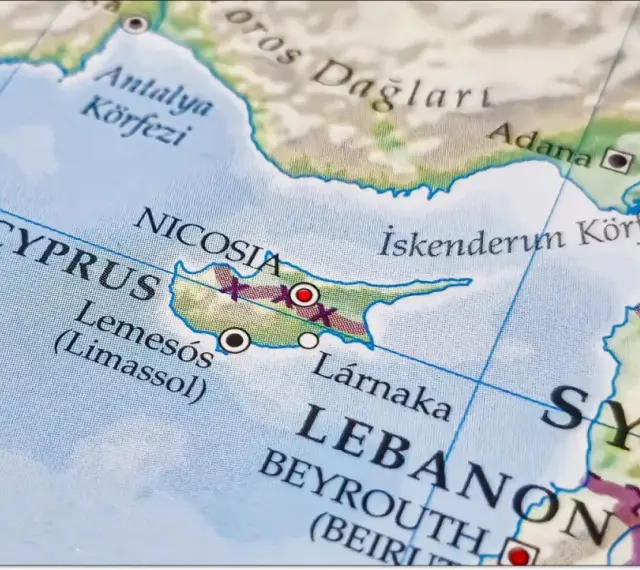 Mapa pokazuje, gdzie leży Cypr, między Turcją a Syrią, z zaznaczonymi Nikozją, Limassol i Larnaką.